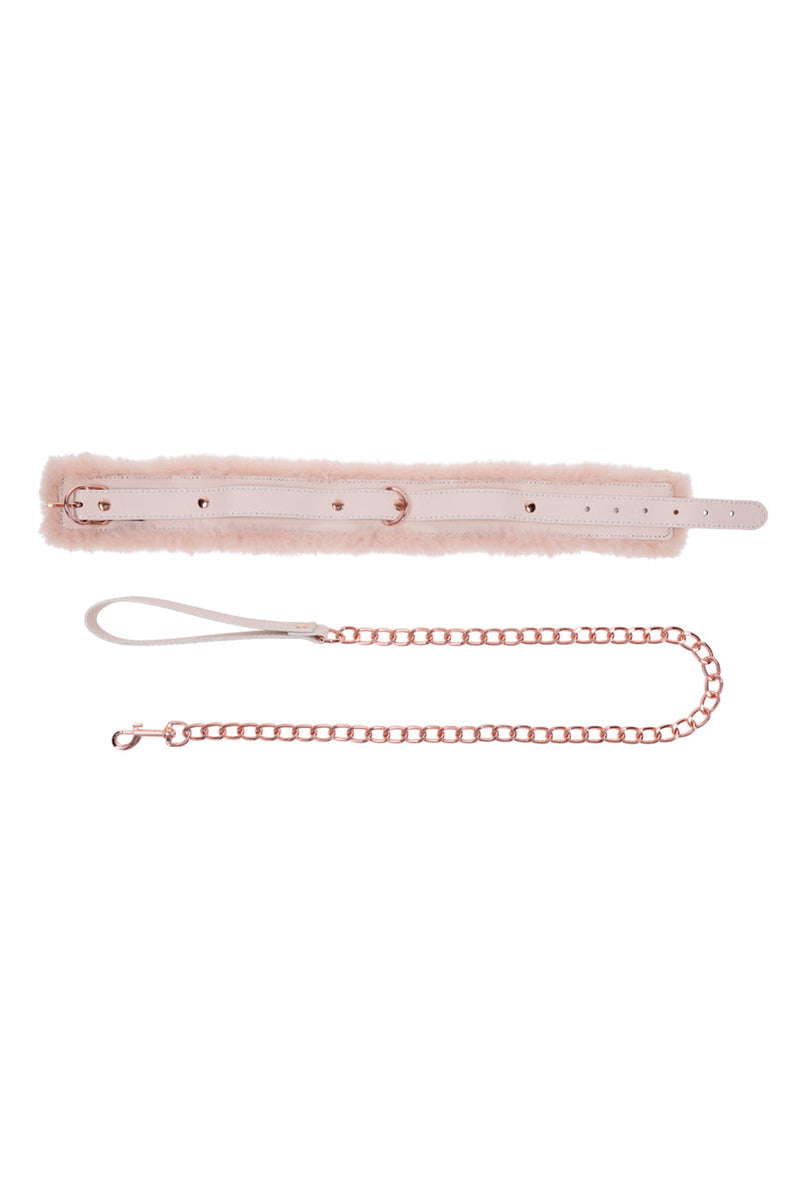 Detail view of the peach fur collar laid flat with rose-gold rivets, beside the rose-gold chain leash and cream hand loop.