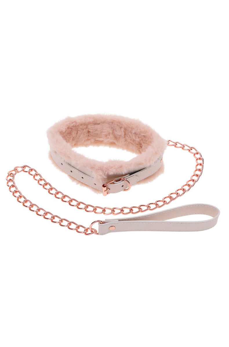 Close-up of the peach faux fur collar with rose-gold buckle and D-ring, and the rose-gold chain leash coiled below.