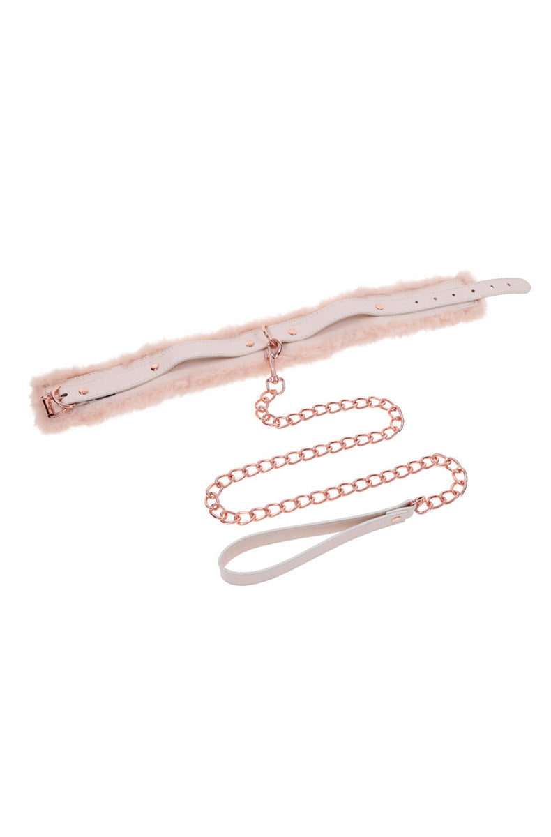 Back view of the peach fur collar showing the cream leather strap and rose-gold rivets, with rose-gold chain leash below.