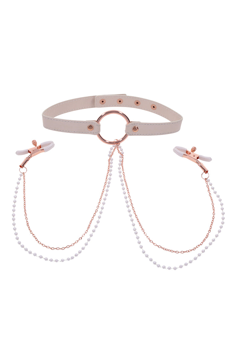 Cream faux leather collar with rose-gold O-ring and dual chains dropping to white-tipped rose-gold tweezer nipple clamps.