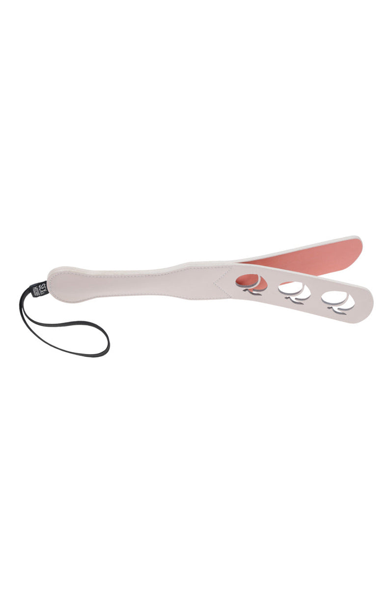 Back view of the cream paddle showing a flat coral inner layer visible through the three peach cutouts.