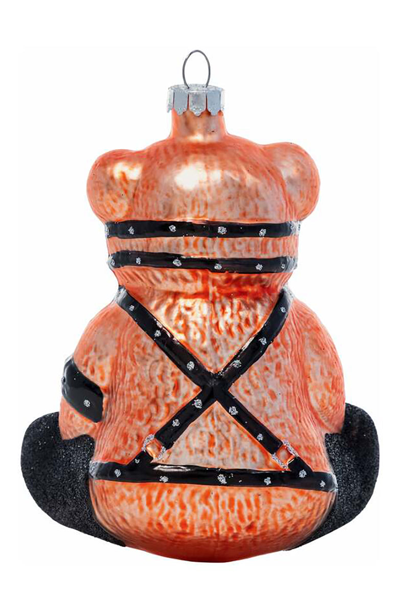 Side view of hand-blown glass teddy bear ornament showing black harness straps and glitter feet.