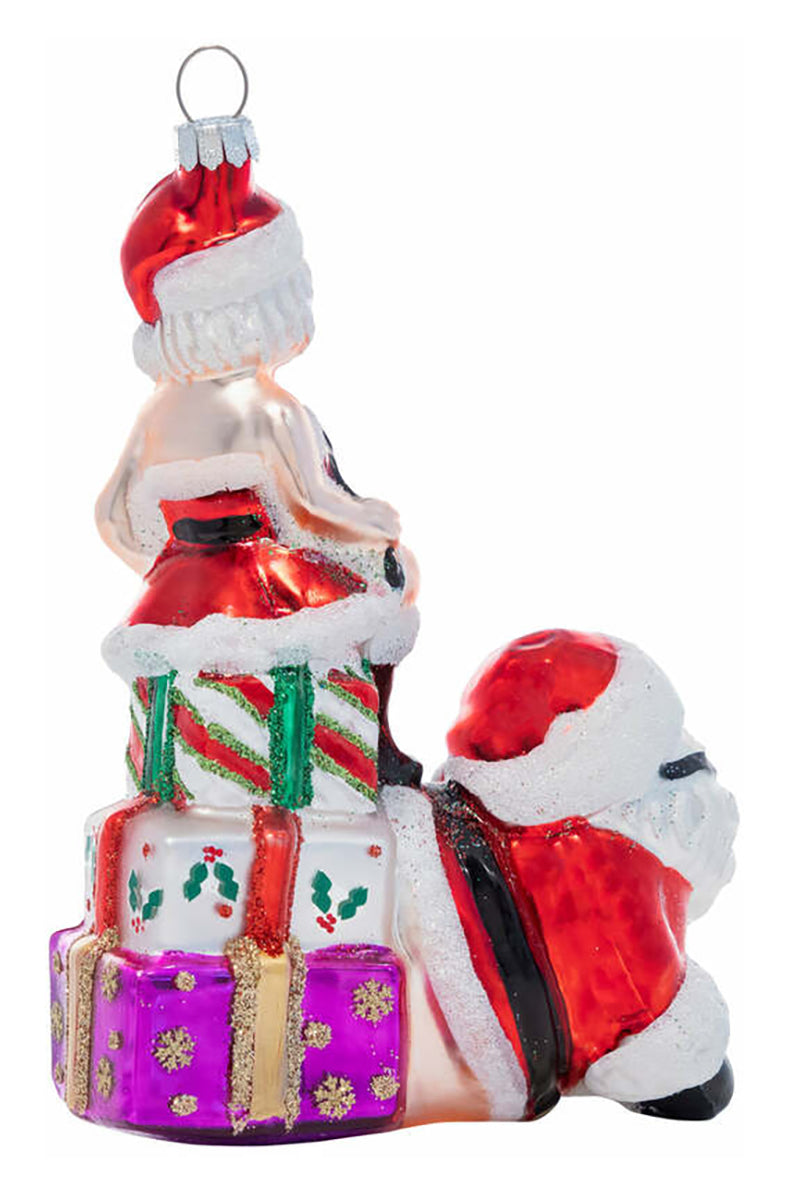 Side view of hand-blown glass Santa ornament showing Mrs. Claus standing on the back of kneeling Santa.