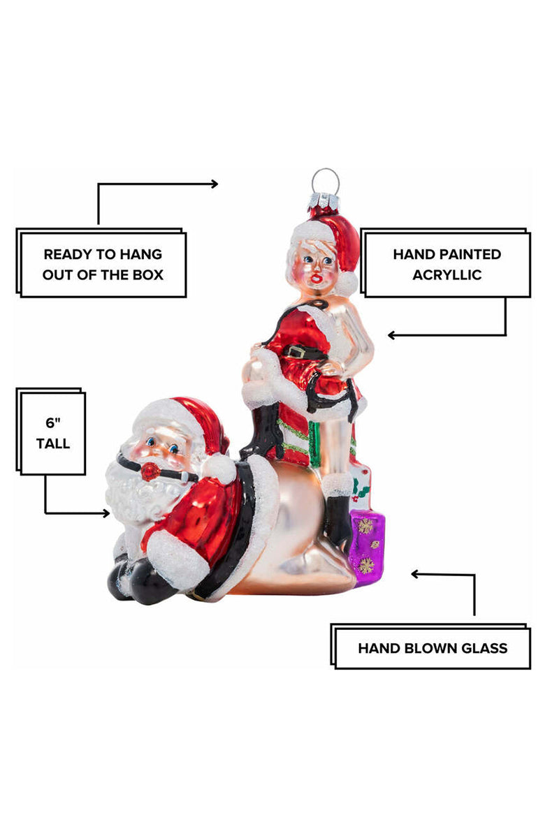 Close-up of red ball gag on Santa Claus face on hand-blown glass kneeling ornament.