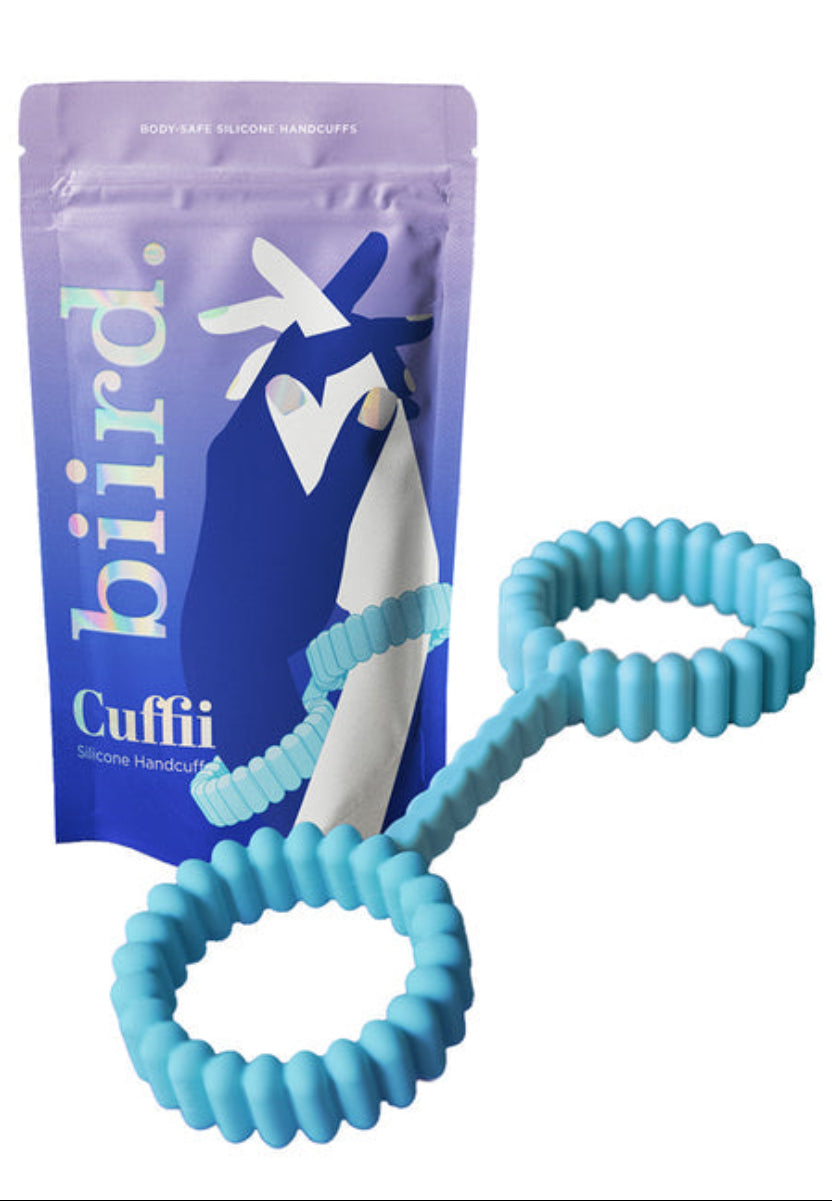 Mint silicone Cuffii cuffs, two ribbed stretch loops on a short bridge, beside the purple Biird Cuffii pouch, on white.