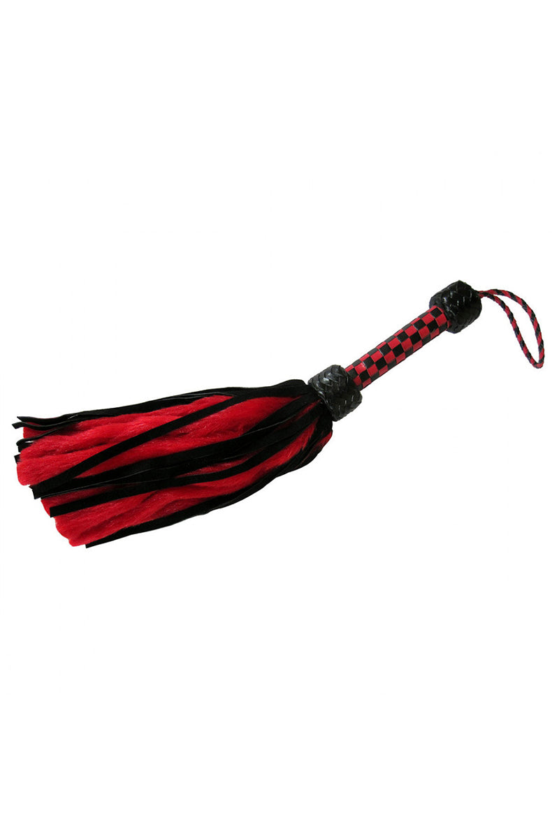 Full view of the red and black suede and fluff flogger hanging by its red and black braided wrist cord.