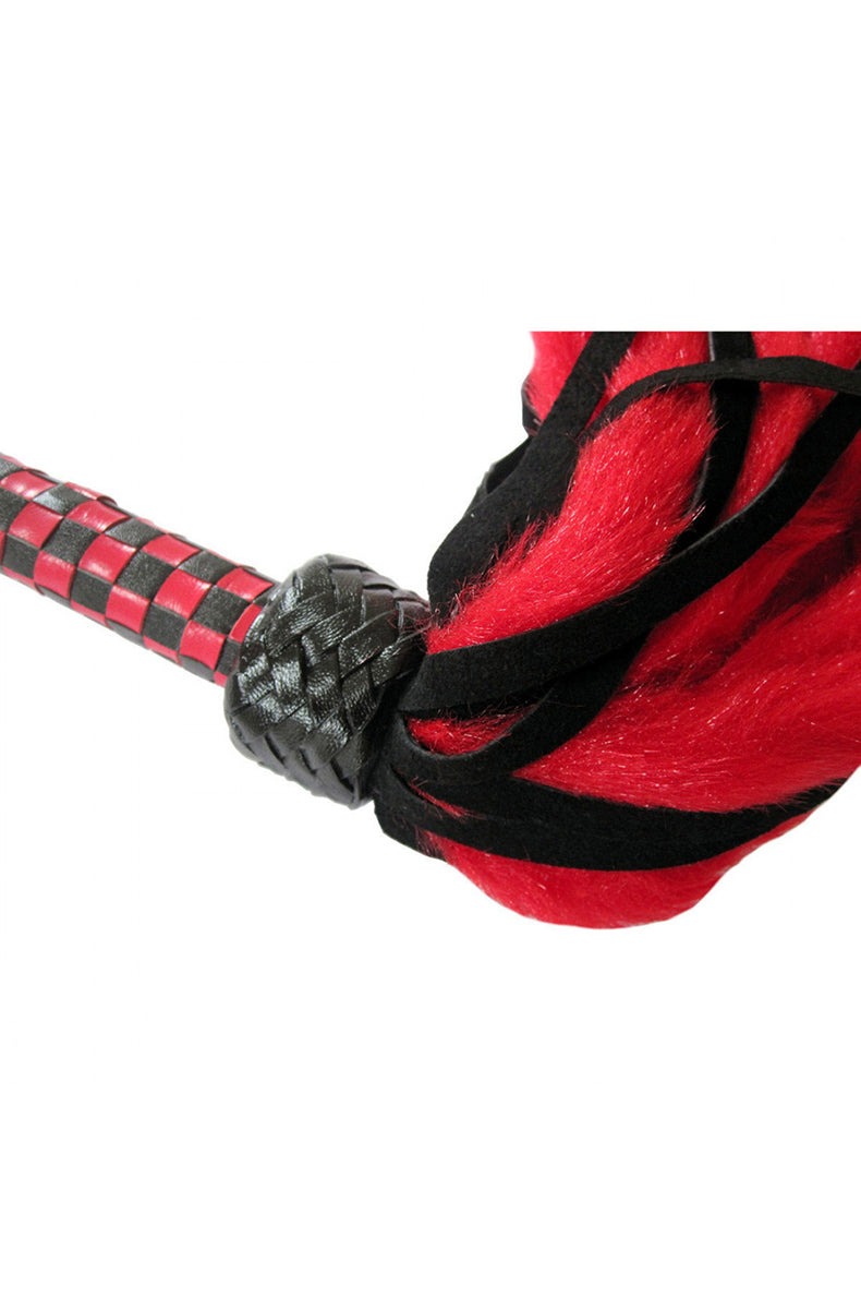 Detail view of the braided black collar joining red faux-fur and black suede tails to the checkered handle.