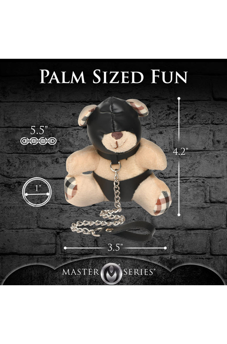 Close-up of black PU leather hood with eye openings on tan plush teddy bear keychain face.