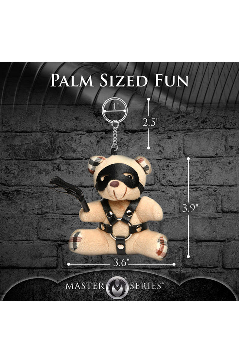 Detail view of silver O-rings and black PU harness straps on tan plush teddy bear keychain chest.