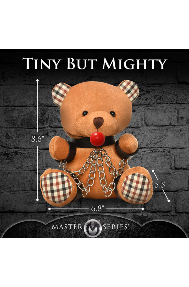 Detail view of black wrist cuffs, silver chains, and silver key ring on tan plush teddy bear keychain.