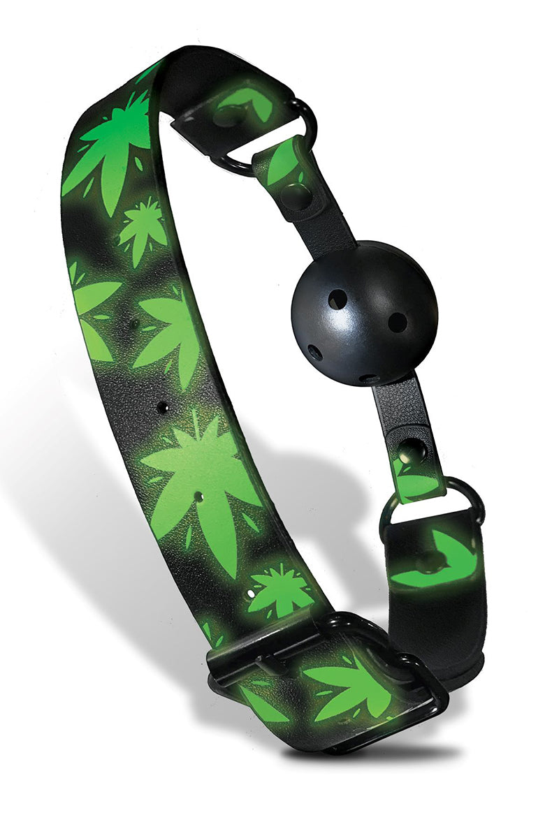 Stoner Vibes ball gag with glow-in-the-dark cannabis-leaf print strap, black breathable ball, and metal buckle hardware.