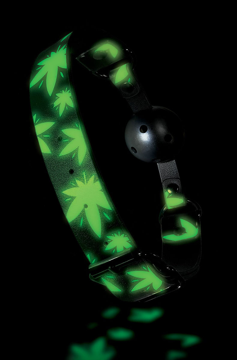 Faux-leather ball gag strap printed with green cannabis leaves and a black breathable ball with airholes.