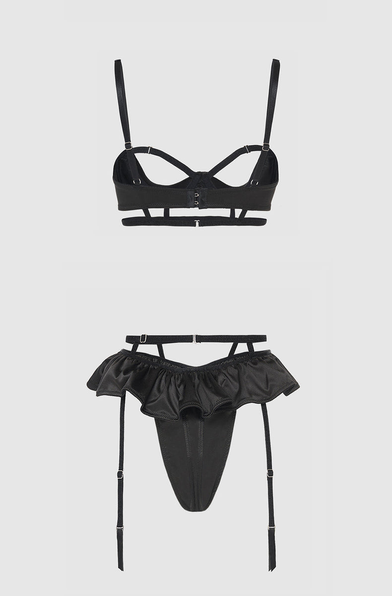 Black satin open cup bra and skirted thong laid flat from the back