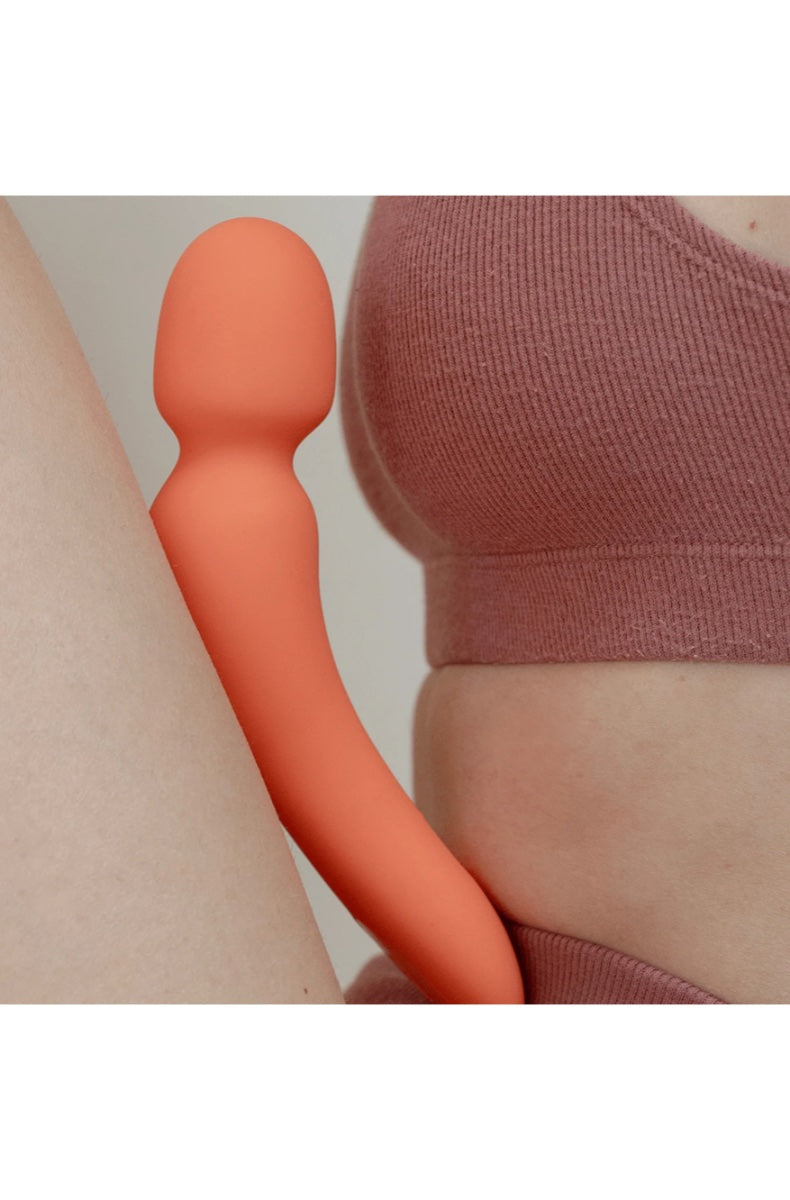 Lifestyle shot of coral wand next to model in coral ribbed top