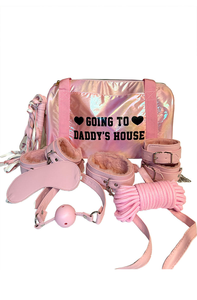 Pink iridescent duffle bag labeled Going To Daddy's House with the 7 piece kit: blindfold, gag, cuffs, flogger, rope.