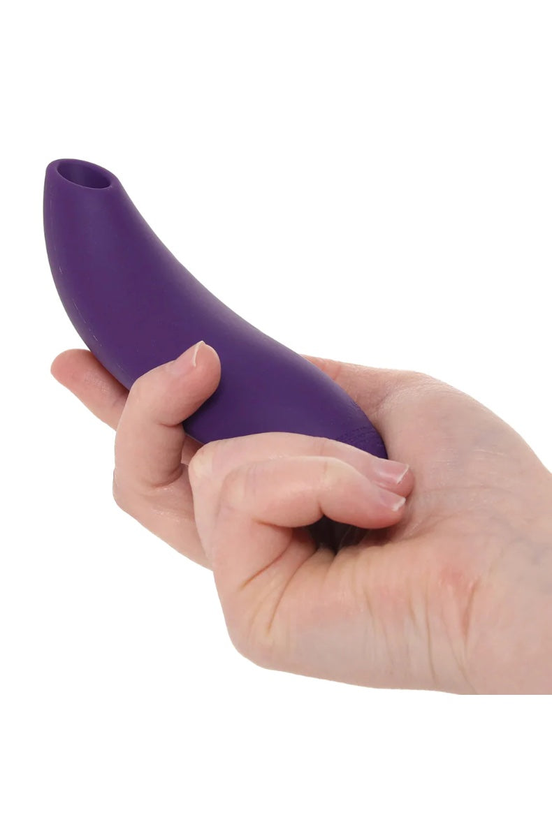 Purple vibrator held in cupped palms showing ergonomic curved design