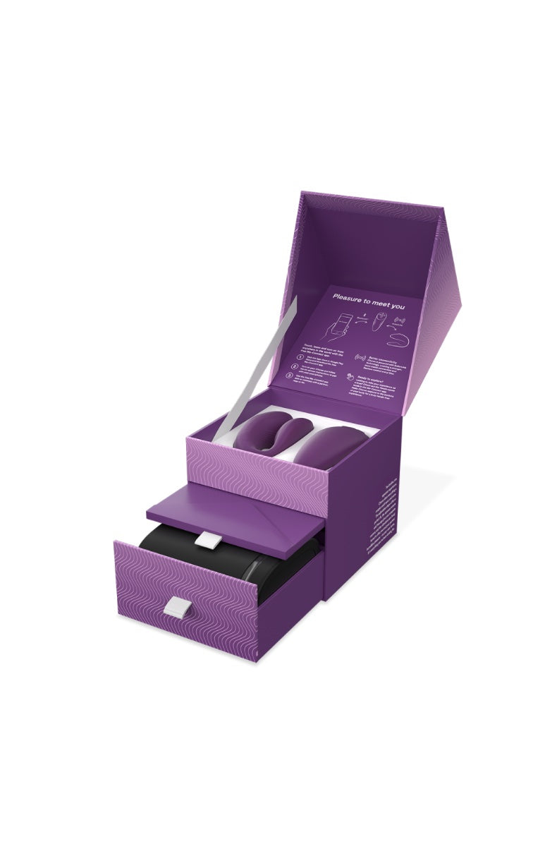 Open purple retail box showing couples vibrator set with charging base in lower drawer