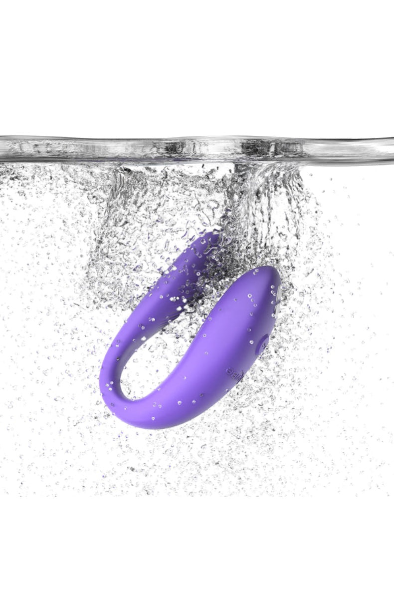 Purple U-shaped vibrator splashing into clear water