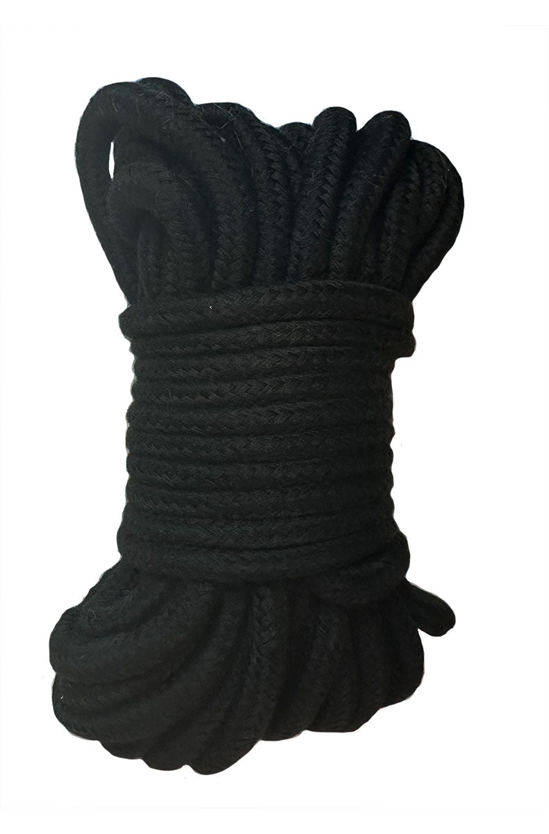 Close-up of black satin blindfold with elastic strap folded on a flat surface.