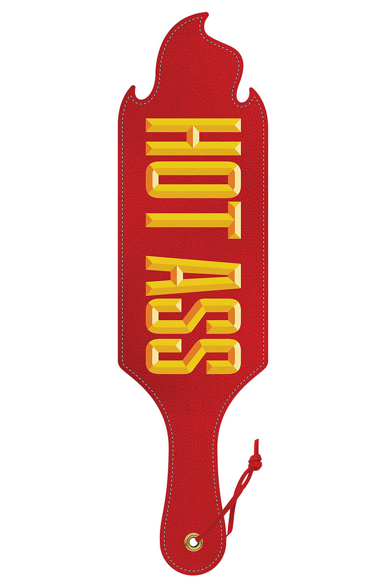 Red faux leather paddle with HOT ASS in bold yellow 3D block lettering and a flame-shaped cut top edge, with red wrist cord.