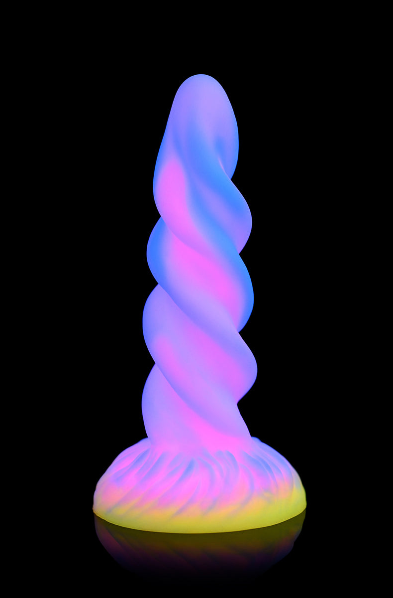 Side view of pastel spiral unicorn horn glow silicone dildo with twisted ridges and pointed tip.