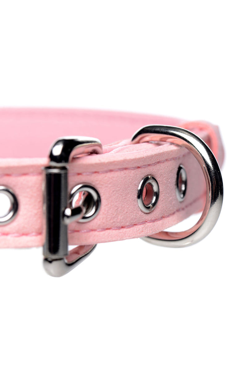 Pink suede-finish vegan leather collar with a small pink bow at the front and a silver jingle bell hanging below.