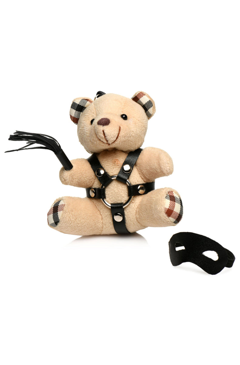 Back view of tan plush teddy bear keychain showing harness back straps and silver key ring.