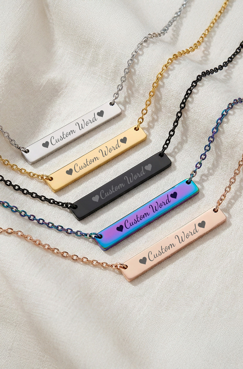 Five custom bar necklaces in silver, gold, black, rainbow, and rose gold with "Custom Word" engraving and matching chains