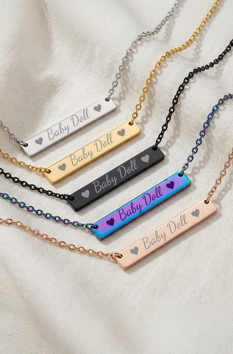 Five Baby Doll bar necklaces showing silver, gold, black, rainbow, and rose gold finishes