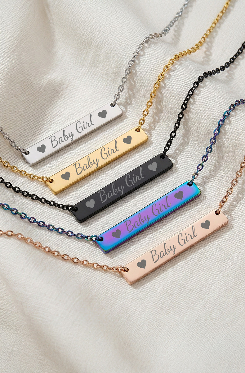 Five bar necklaces showing laser-engraved "Baby Girl" text in silver, gold, black, rainbow, and rose gold finishes