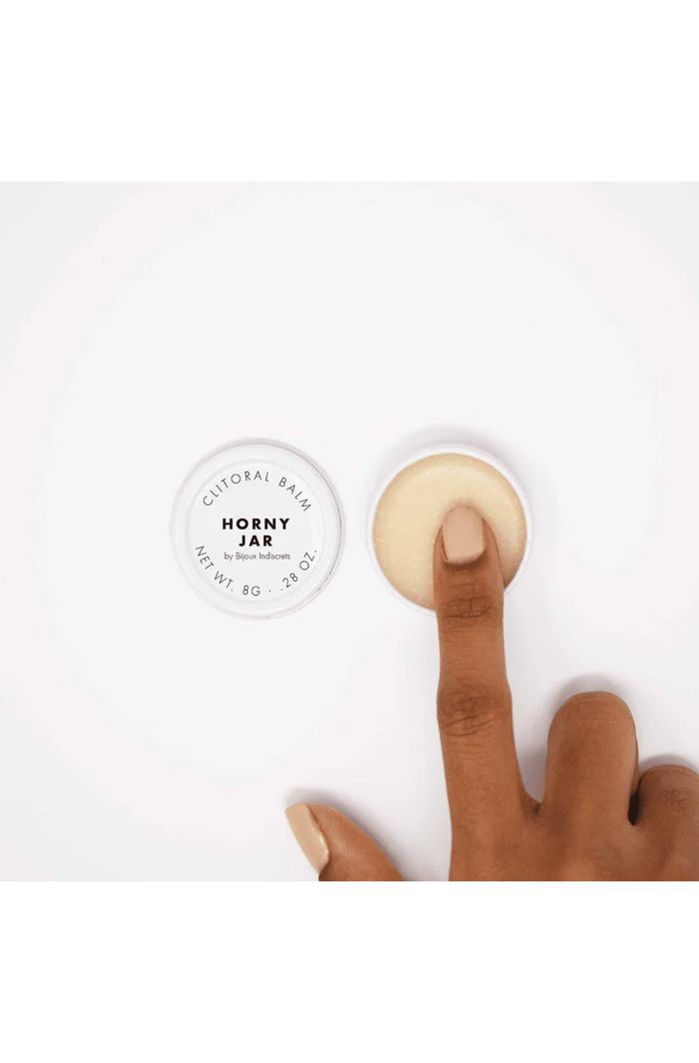 Bijoux Clitherapy Horny Jar open balm tin with a finger swiping balm