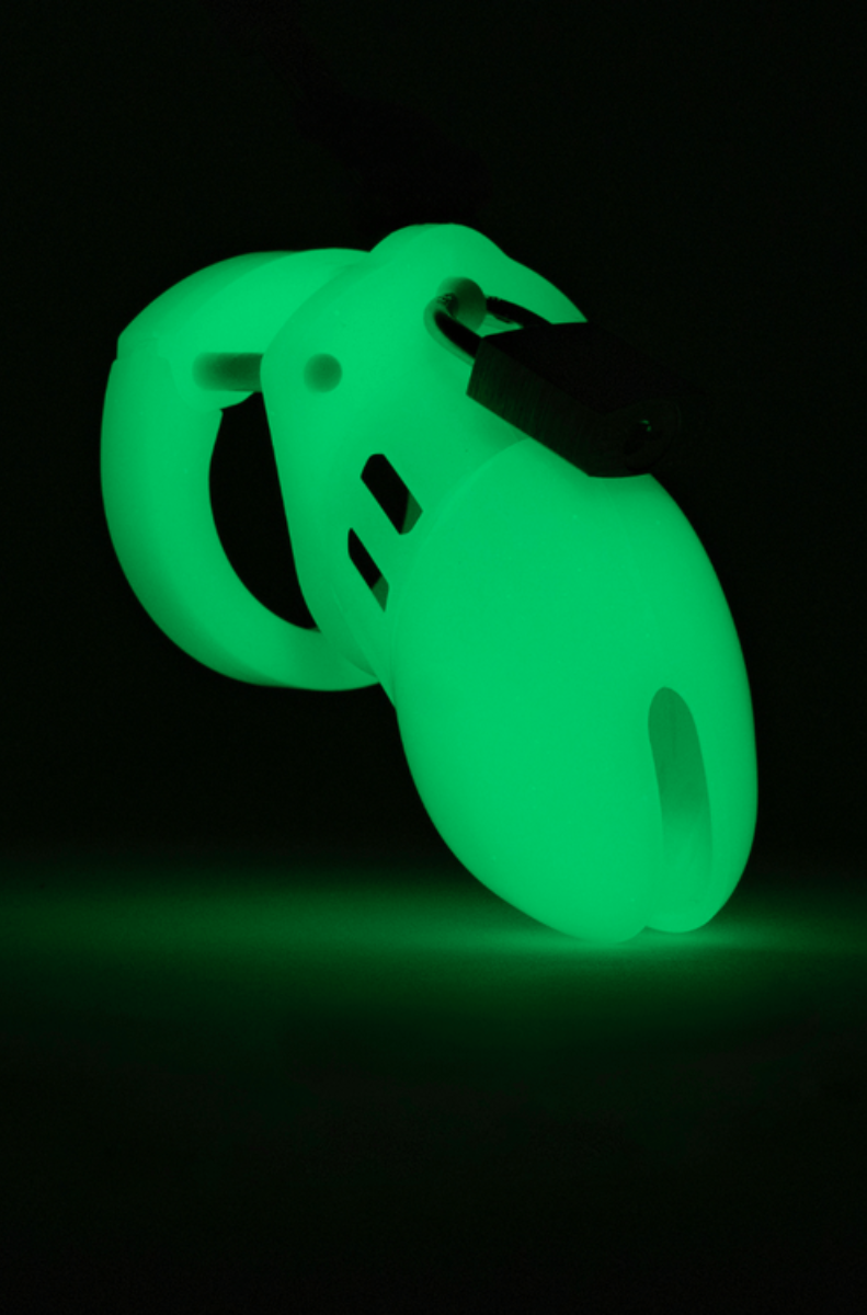 CB-6000S chastity cage and ring glowing bright green in the dark on a black background.