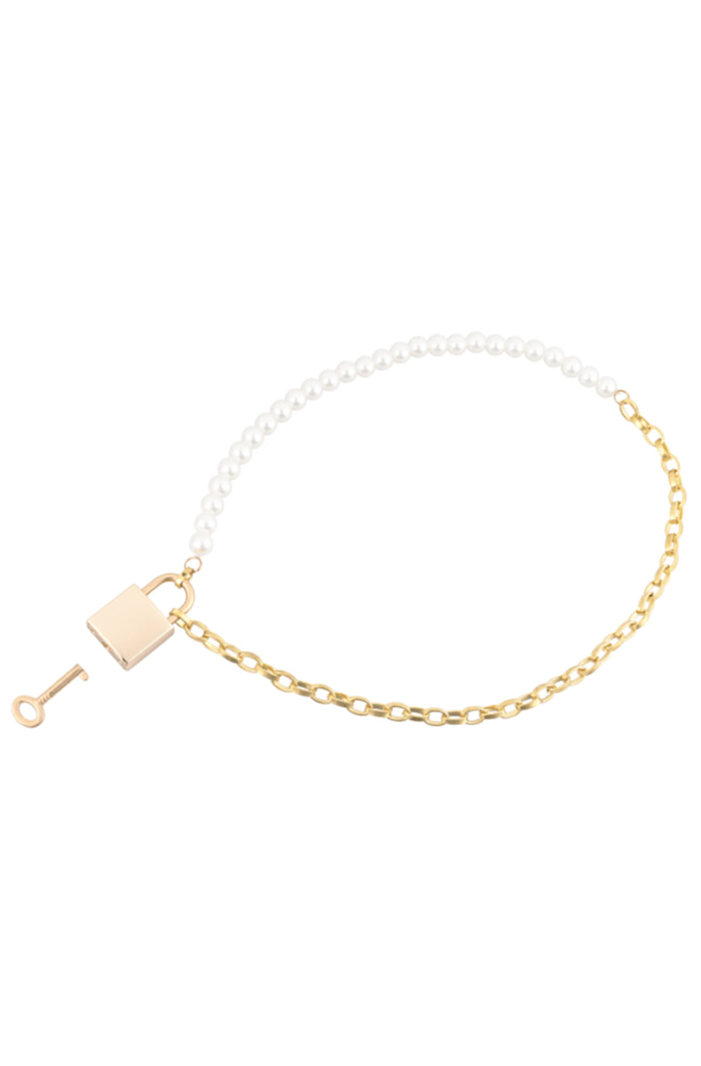 Detail view of the half-pearl half-chain collar laid flat with gold padlock closure and small gold key set to the side.