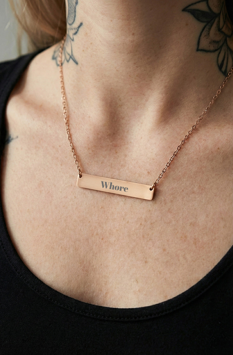 Rose gold bar necklace on delicate chain worn by tattooed model