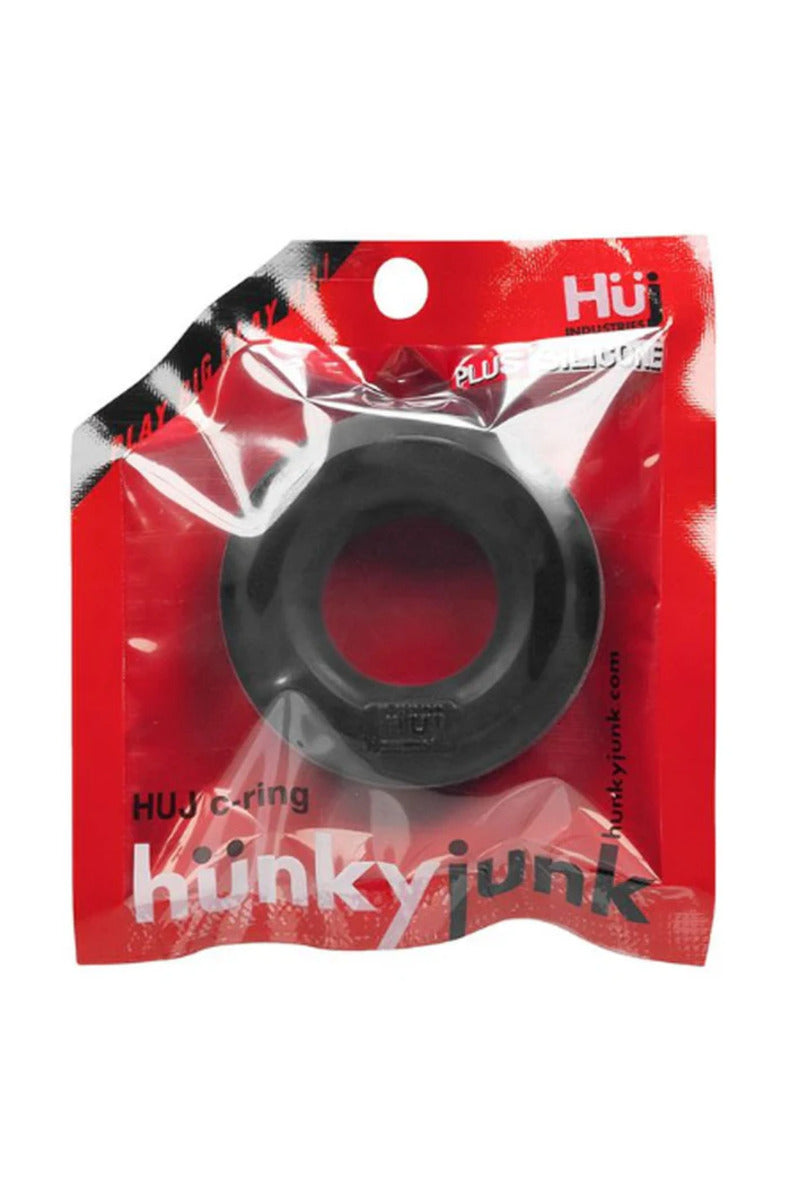 Tar black Hünkyjunk HUJ thick silicone cock ring in its red Hünkyjunk package, on a white background.