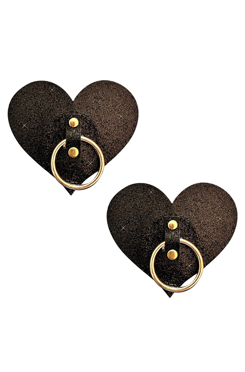 Black glitter heart-shaped pasties with a gold-tone metal hoop ring at the center on a studded vinyl strap.