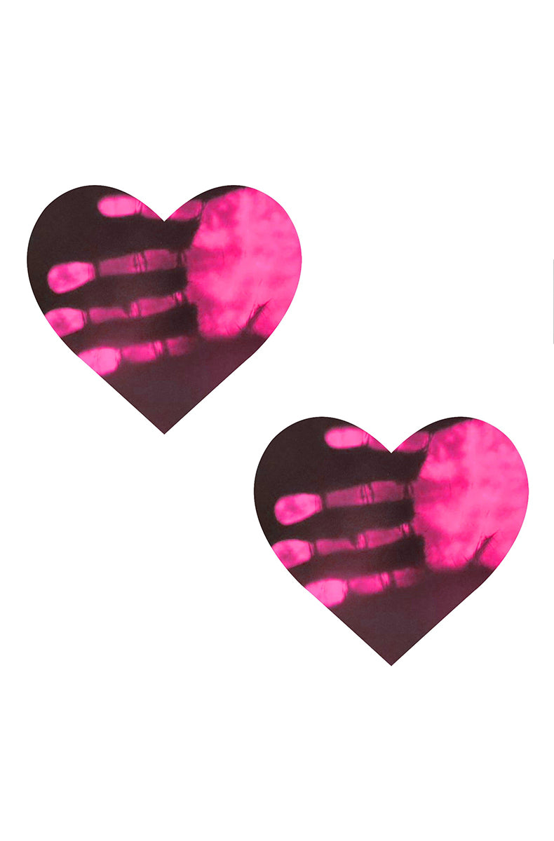 Two heart-shaped pasties in matte black with neon pink color revealed where a warm hand has been pressed against the surface.