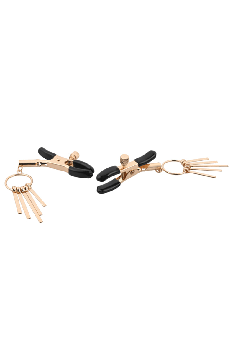 Detail view of rose-gold filigree cage pendants holding faux pearls hanging from the tweezer clamps.