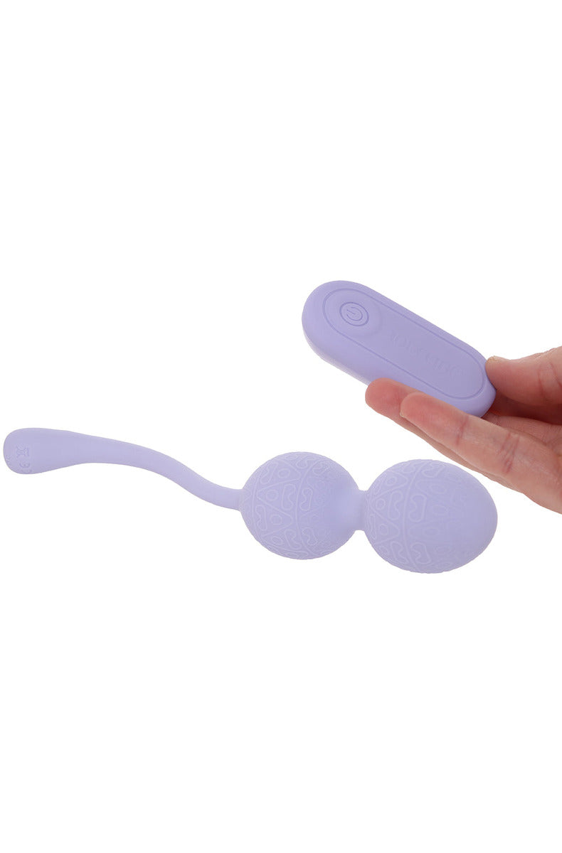 Lavender kegel vibrator beads with the matching wireless remote held in a hand.