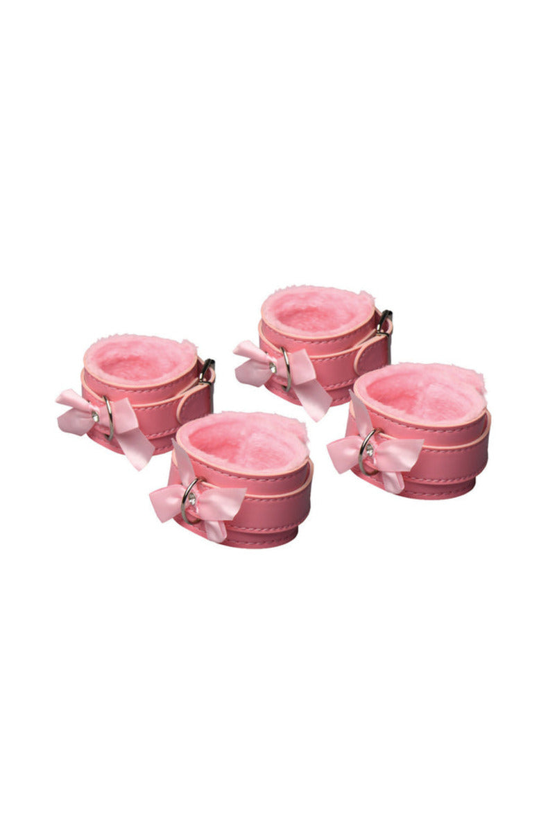 Four pink faux-fur-lined cuffs with bow accents and silver D-rings, on a white background.