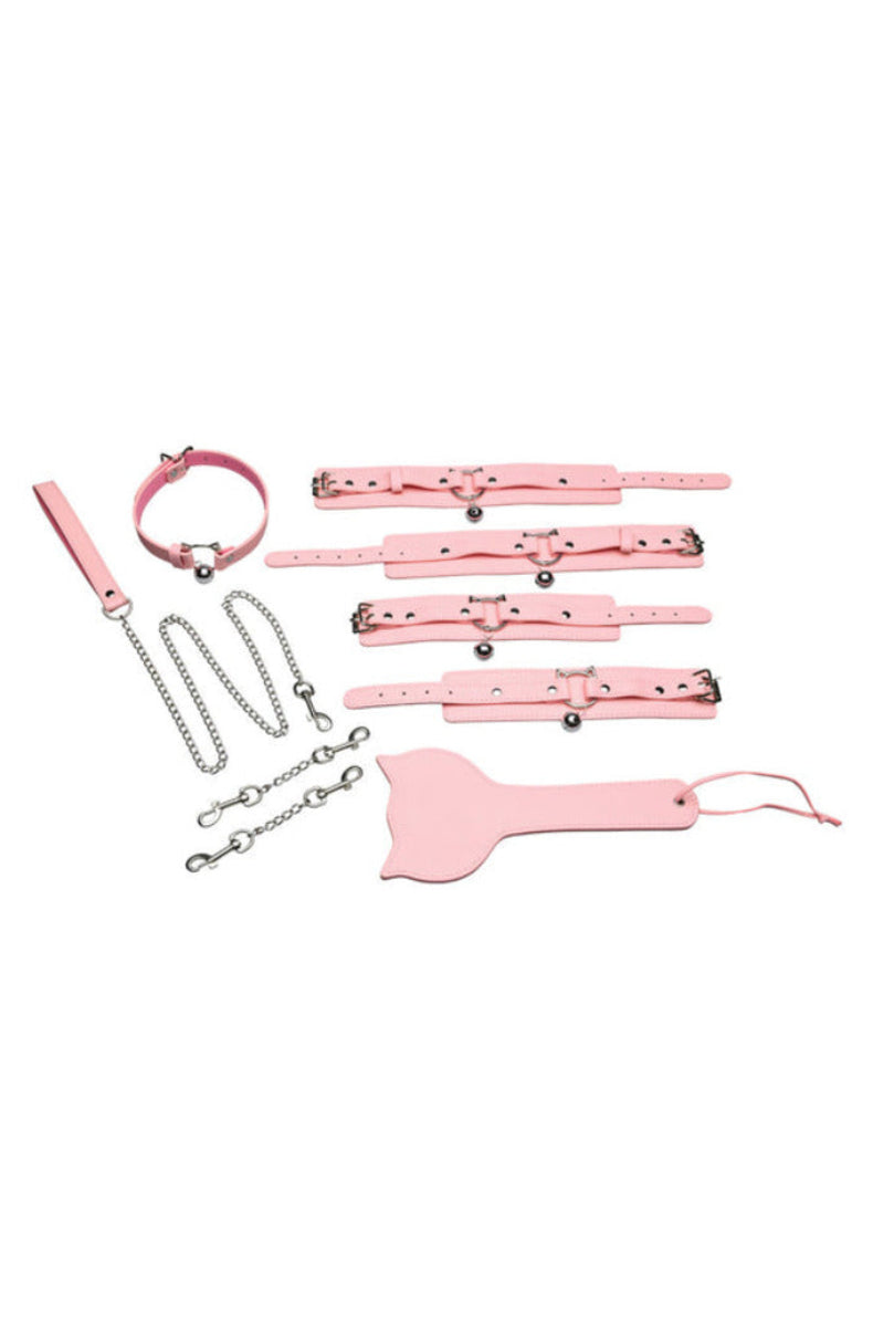 Soft pink kitty bondage set flat lay: belled collar, chain leash, four cuffs, connectors, and a kitty-head paddle.