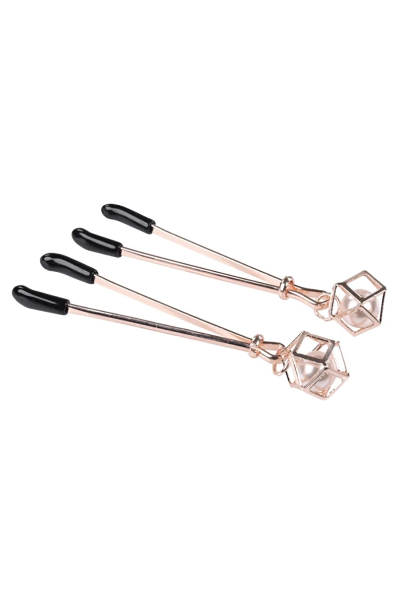 Close-up of rose-gold tweezer jaws with black thermoplastic rubber tips and slider adjustment.