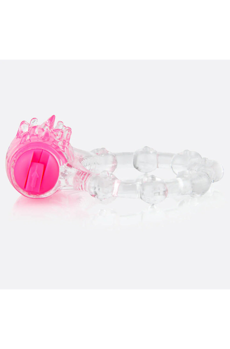 Clear stretchy vibrating cock ring with a pink motor, soft ticklers, and a beaded band, on white.