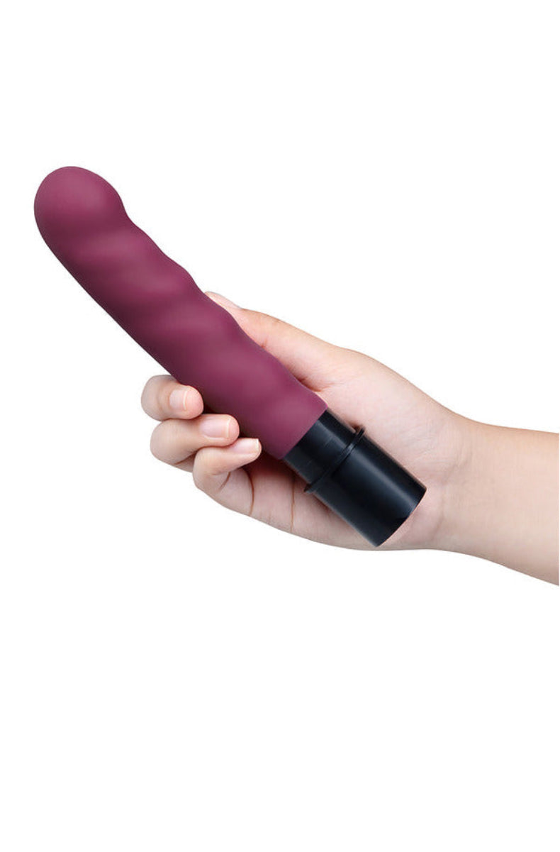 Hand holding the burgundy thrusting attachment for The Cowgirl Thrust Rider to show its size