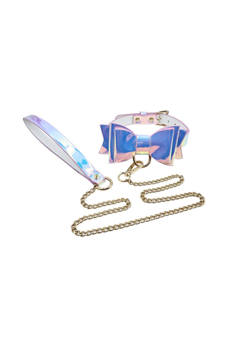 Iridescent pastel bow collar with a gold D-ring and a gold chain leash with a holographic wrist strap, on white.