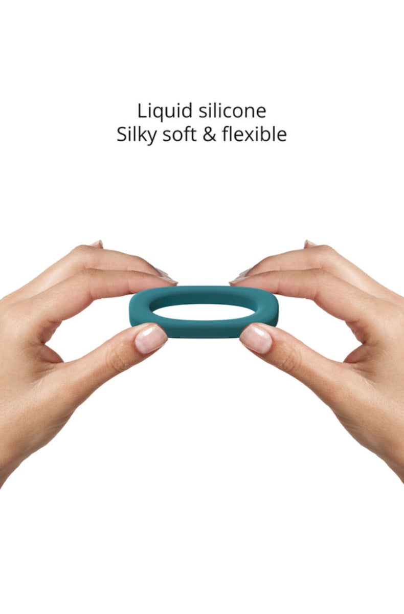 Hands demonstrating flexibility of teal silicone cock ring being compressed