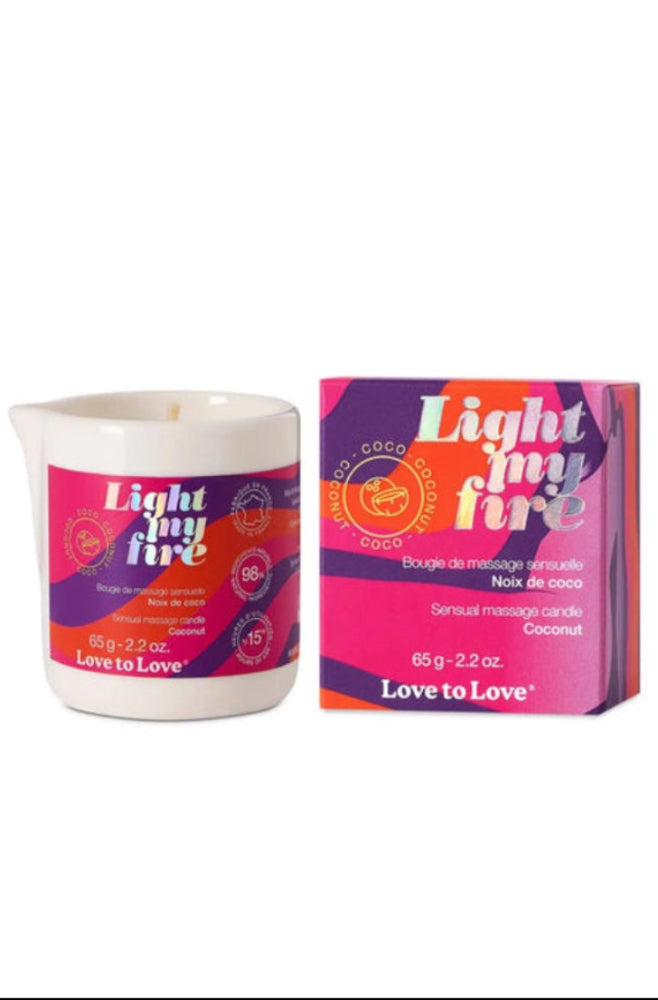 White ceramic jar with pink and purple gradient label showing Light My Fire coconut massage candle and matching box