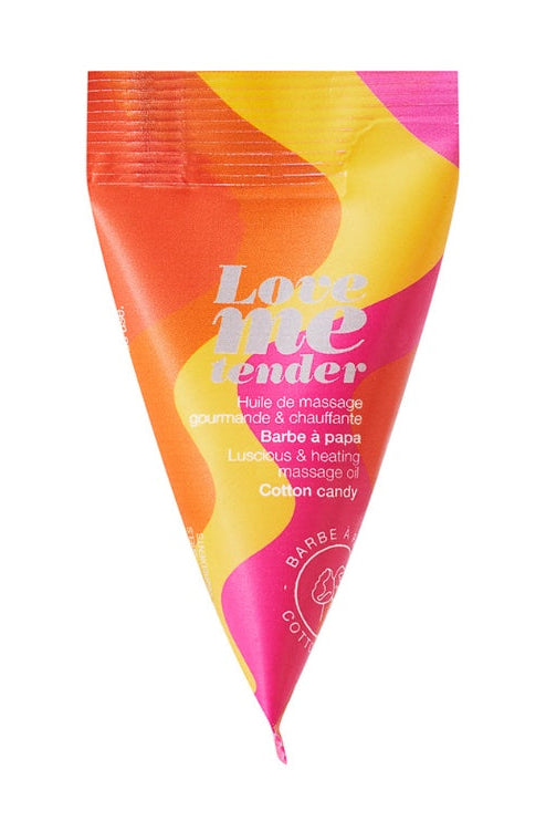 Triangle packet of Love Me Tender massage oil in orange, yellow, and pink gradient with cotton candy scent label