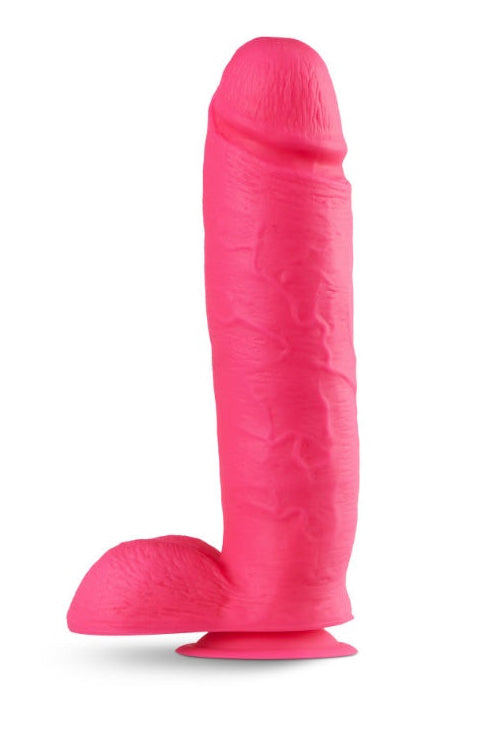 Side angle of bright pink dildo displaying suction cup base and overall silhouette