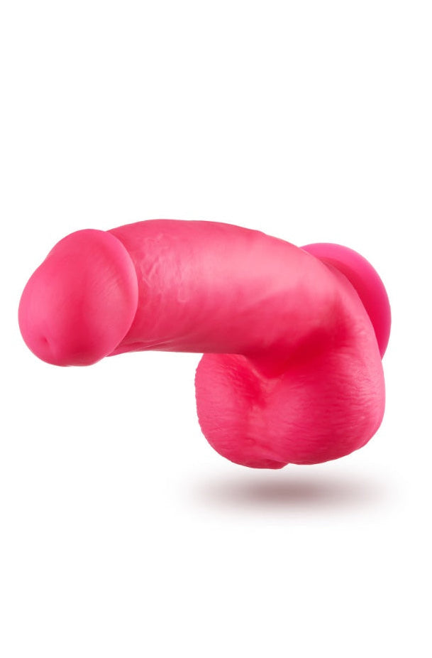 Pink silicone dildo viewed from underneath showing suction cup base and realistic testicle texture
